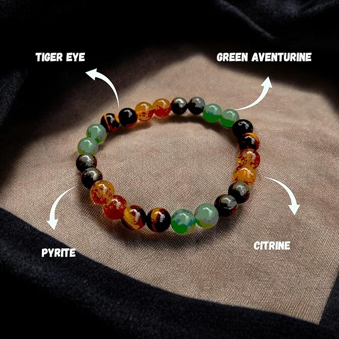 Bracelet with colored beads labeled 'Tiger Eye', 'Green Aventurine', 'Pyrite', and 'Citrine' on a textured surface.
